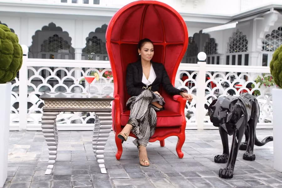 Thu Minh ngồi trên chiếc ghế đỏ rực.