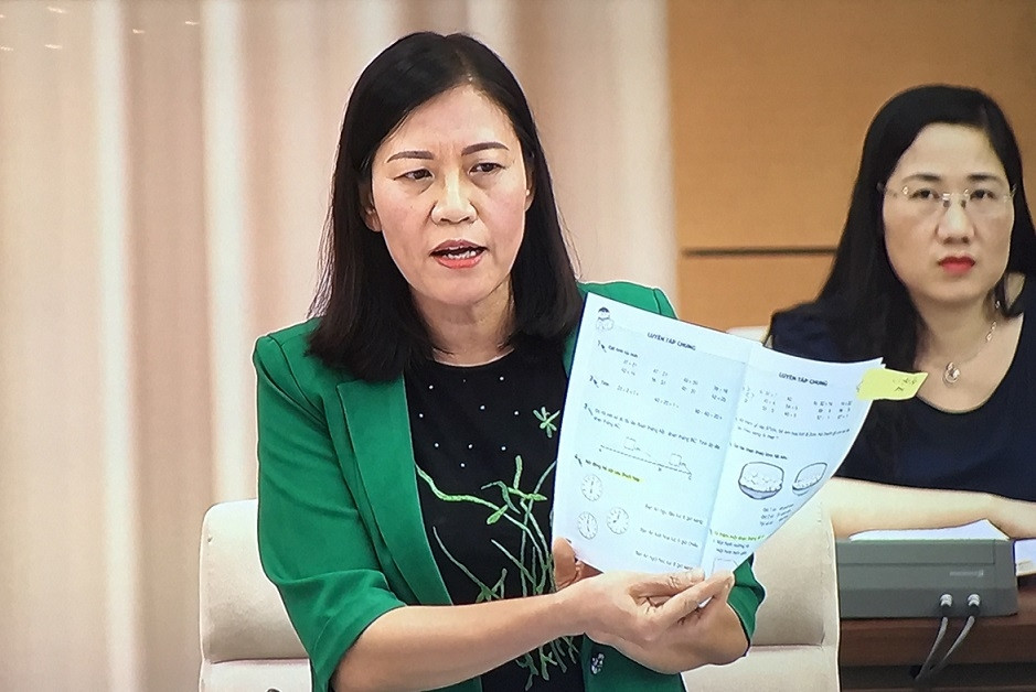 Chủ nhiệm Ủy ban Tư pháp Lê Thị Nga giơ quyển sách giáo khoa Toán lớp 1 hiện hành để minh họa cho phát biểu của mình tại phiên họp. Ảnh: Kim Thanh / Báo Điện tử Đảng Cộng sản Việt Nam.