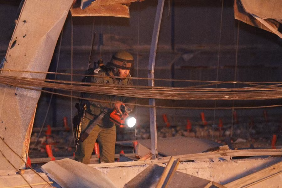 Một binh sĩ Israel đang kiểm tra tòa nhà bị hư hỏng do trúng tên lửa từ Lebanon Một binh sĩ Israel đang kiểm tra tòa nhà bị hư hỏng do trúng tên lửa từ Lebanon