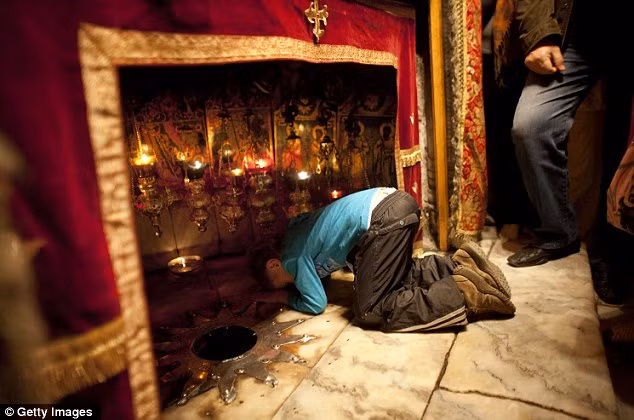 Một cậu bé cầu nguyện tại hang trong nhà thờ Bethlehem