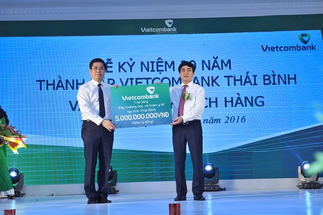 Ông Nghiêm Xuân Thành - Ủy viên Ban Chấp hành Đảng bộ Khối Doanh nghiệp Trung ương, Bí thư Đảng ủy, Chủ tịch Hội đồng quản trị Vietcombank (bên phải) trao số tiền 5 tỷ đồng tài trợ xây dựng 1 trường học, 1 trạm y tế cho tỉnh Thái Bình.