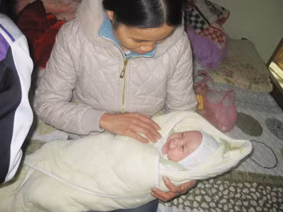 Cháu Phạm Xuân Hà bên người bác họ trong ngày lễ đầy tháng "muộn" 11/12.