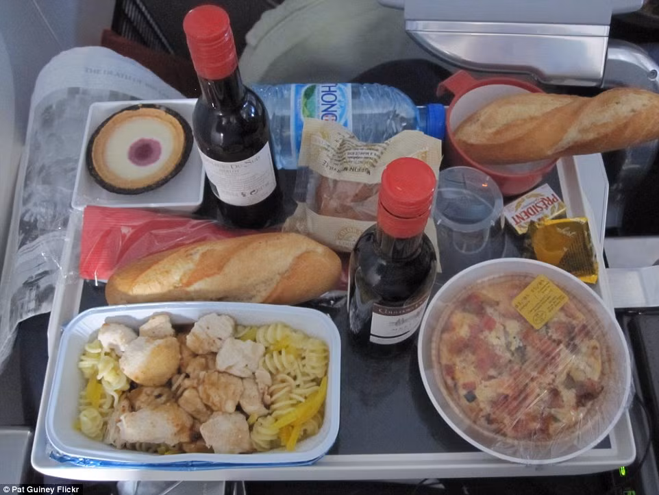 Bữa ăn của Air France có mì xào gà, rượu vang đỏ, bánh mì, chai nước và bánh ngọt để tráng miệng. Bữa ăn của Air France có mì xào gà, rượu vang đỏ, bánh mì, chai nước và bánh ngọt để tráng miệng.