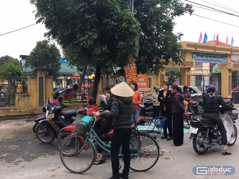 Nhiều phụ huynh bức xúc kéo đến cổng Trường mầm non Thanh Khương để nói về chuyện con em họ đi học ăn phải thịt lợn nghi nhiễm sán gạo. Ảnh: Vũ Phương.