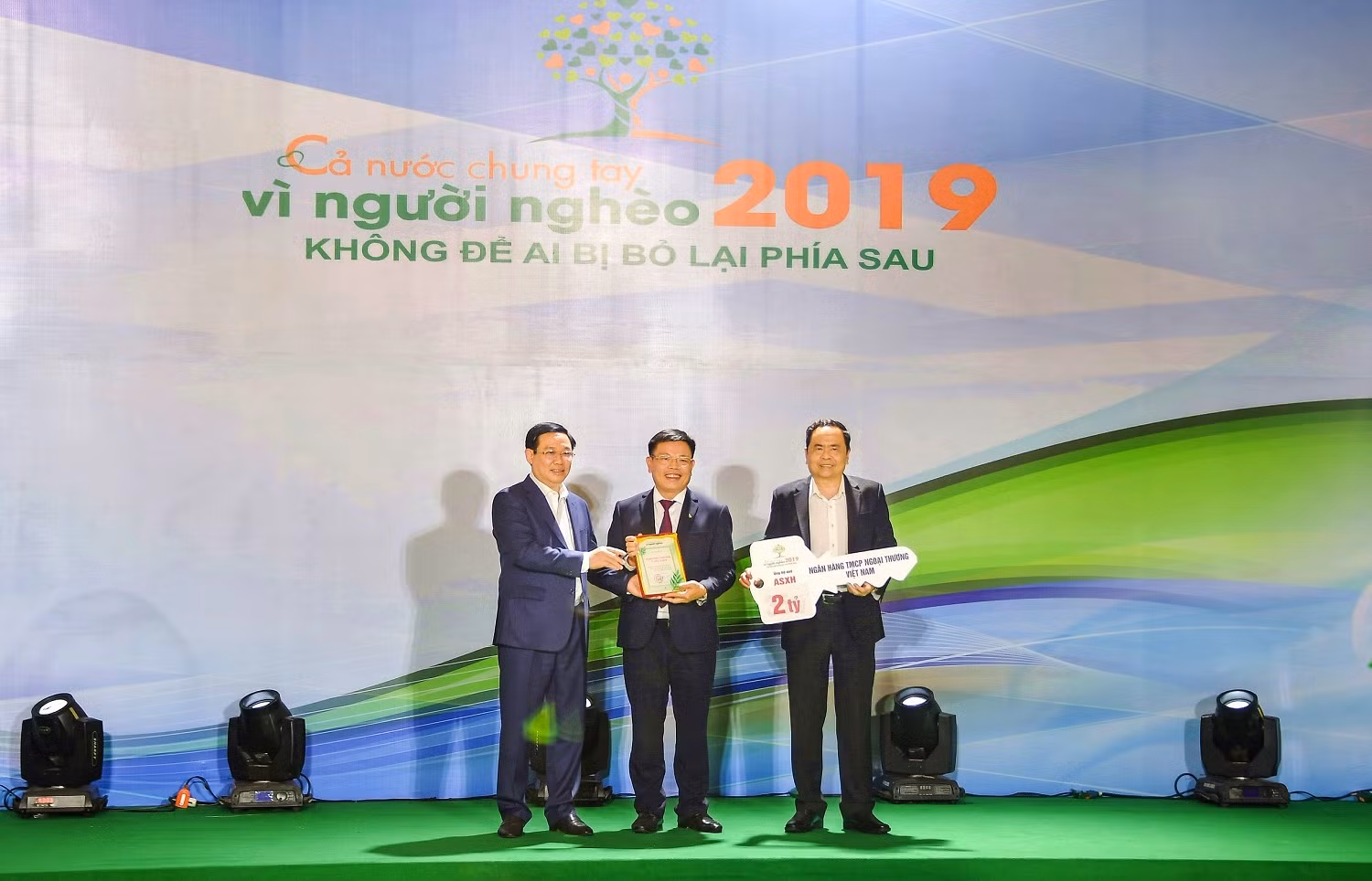 Đồng chí Vương Đình Huệ - Ủy viên Bộ Chính trị, Phó Thủ tướng Chính phủ (ngoài cùng bên phải) trao chứng nhận cảm ơn Vietcombank với những đóng góp cho chương trình “Cả nước chung tay vì người nghèo 2019, không để ai bị bỏ lại phía sau”.