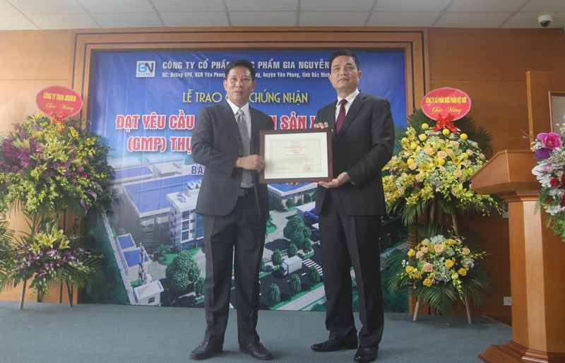 Ông Nguyễn Thanh Phong (phải), Cục trưởng Cục An toàn thực phẩm – Bộ Y tế cấp giấy chứng nhận đạt yêu cầu “thực hành sản xuất tốt” (GMP) thực phẩm bảo vệ sức khỏe cho Công ty Cổ phần Dược phẩm Gia Nguyễn, có địa chỉ tại Khu công nghiệp Yên Phong (Bắc Ninh). Ảnh: Minh Chí.