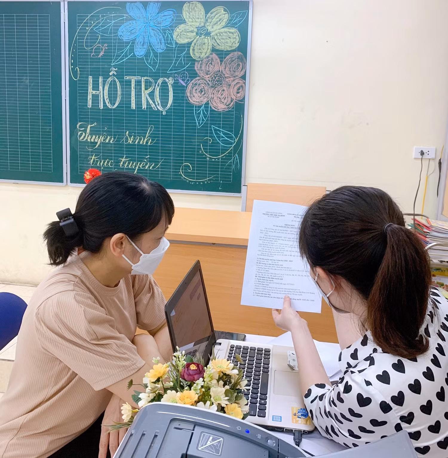 Giáo viên tận tình hướng dẫn phụ huynh. Trước đó, Sở Giáo dục và Đào tạo Hà Nội đã lưu ý: Tuyệt đối không được lấy lại mật khẩu trên hệ thống cơ sở dữ liệu ngành đã được cấp cho học sinh. Trường hợp đã thay đổi mật khẩu, giáo viên chủ nhiệm phải hỗ trợ và cung cấp cho phụ huynh đảm bảo việc đăng ký tuyển sinh trực tuyến bảo mật và thuận lợi. (Ảnh: Trường Tiểu học Ba Đình).