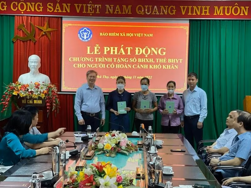 Trần Thị Tân (thứ 2 từ trái sang phải) nhận sổ bảo hiểm xã hội tại lễ phát động tặng sổ bảo hiểm xã hội, thẻ bảo hiểm y tế.