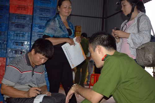 Tuy nhiên, xưởng sản xuất này vẫn cho ra đời hàng loạt chai nước tăng lực không đảm bảo chất lượng. Về vấn đề này, Giám đốc Cty TNHH Hưng Phát, ông Nguyễn Trọng Tiến giải thích : “Chúng tôi mới sản xuất được 1 tháng, bán ra thị trường chưa đáng bao nhiêu”. Ảnh: Ông Tiến, Giám đốc Cty (ngoài cùng bên trái) làm việc với cơ quan công an.