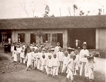 Trẻ em trong một trung tâm nuôi dưỡng ở Hà Nội đang đi vào nhà ăn.