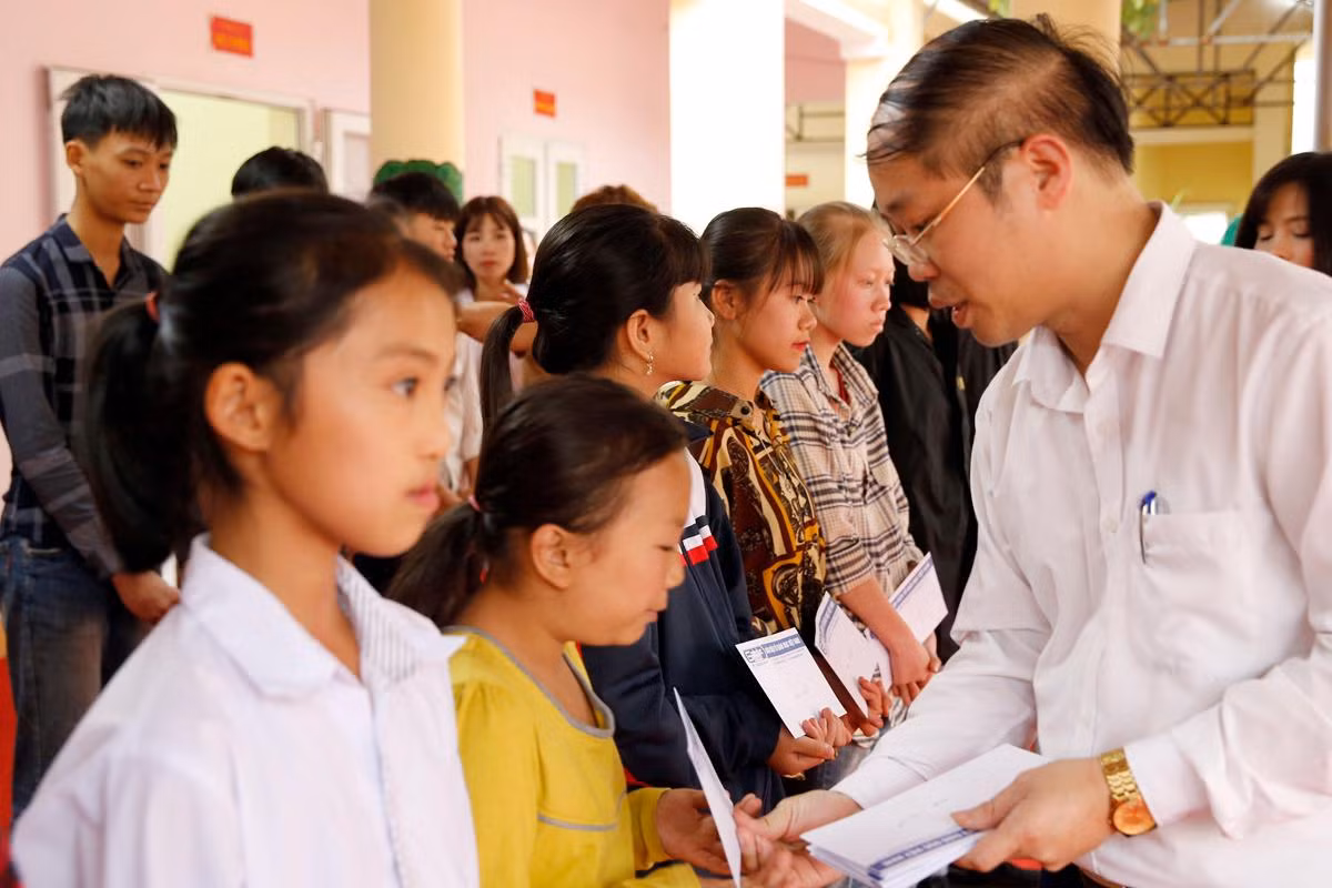 Ông Nguyễn Ánh Hoàng - Trưởng phòng Giáo dục và Đào tạo thị xã Phú Thọ cùng lãnh đạo Tạp chí điện tử Giáo dục Việt Nam trao quà tết cho các em học sinh có hoàn cảnh khó khăn. Ảnh: Tùng Dương.