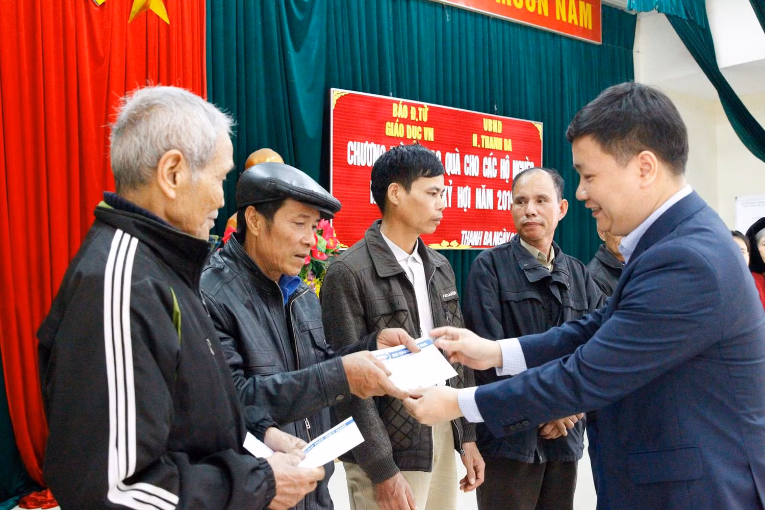 Nhà báo Nguyễn Tiến Bình tặng quà và động viên các gia đình: “Cần phải cố gắng cho con em được học hành đến nơi đến chốn, dù có khó khăn thế nào cũng phải cố gắng khắc phục để các cháu được đến trường”. Ảnh: Tùng Dương.