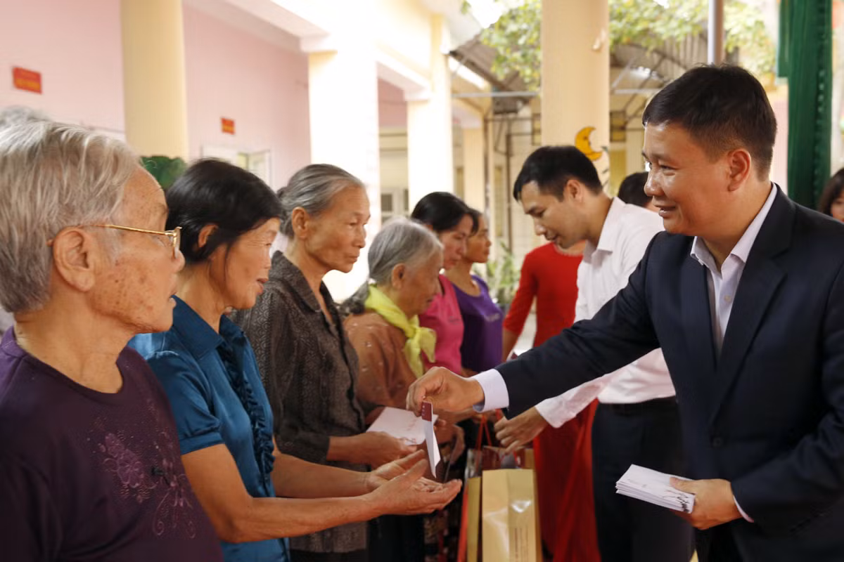 Nhà báo Nguyễn Tiến Bình - Tổng biên tập Báo điện tử Giáo dục Việt Nam, trao quà Tết đến tận tay các hộ nghèo. Ảnh: Tùng Dương.