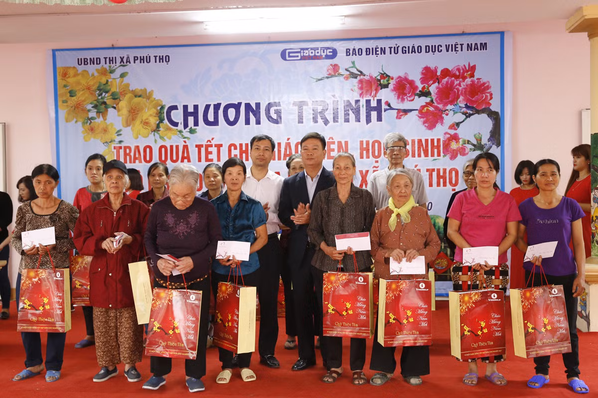 Nhà báo Nguyễn Tiến Bình - Tổng biên tập Báo điện tử Giáo dục Việt Nam (ở giữa bên phải) và ông Nguyễn Tiến Lâm - phó Bí thư thị Ủy, Chủ tịch Ủy ban nhân dân thị xã Phú Thọ (đứng giữa bên trái) với các hộ nghèo trên địa bàn thị xã Phú Thọ. Ảnh: Tùng Dương.