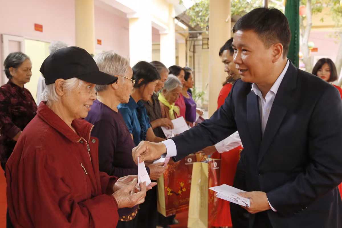 Nhà báo Nguyễn Tiến Bình - Tổng biên tập Báo điện tử Giáo dục Việt Nam, gửi quà và lời chúc sức khỏe đến các hộ nghèo trong thị xã Phú Thọ. Ảnh: Tùng Dương.