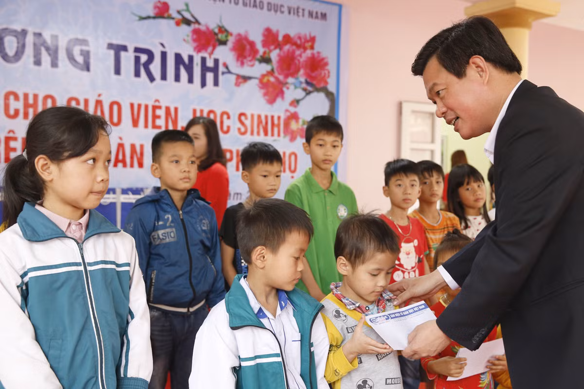Tiến sĩ Trịnh Thế Truyền - Giám đốc Sở Giáo dục và Đào tạo tỉnh Phú Thọ, trao quà Tết cho học sinh có hoàn cảnh khó khăn. Ảnh: Tùng Dương.