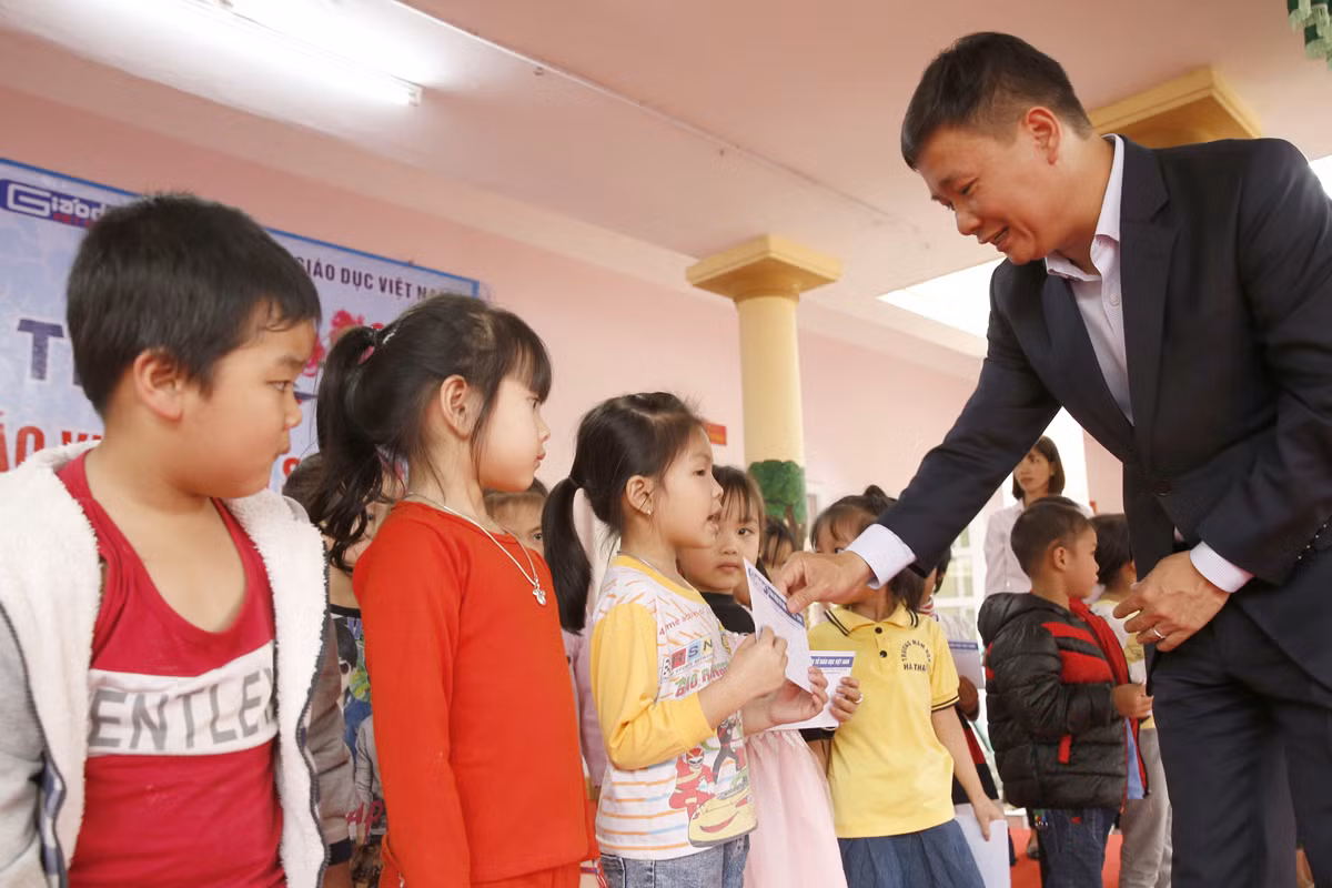 Nhà báo Nguyễn Tiến Bình - Tổng biên tập Báo điện tử Giáo dục Việt Nam, trao quà Tết cho học sinh có hoàn cảnh khó khăn. Ảnh: Tùng Dương.