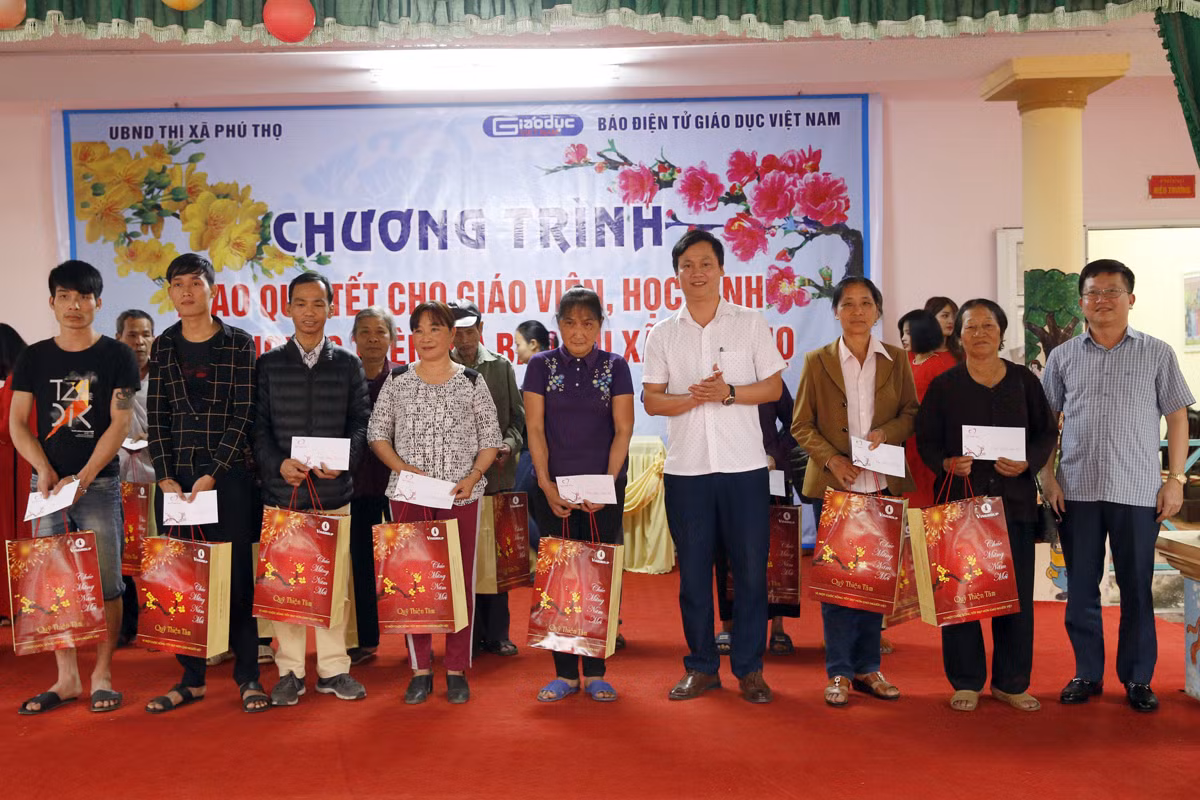 Ông Nguyễn Xuân Lâm - Chủ tịch Ủy ban nhân dân phường Hùng Vương, thị xã Phú Thọ, và ông Nguyễn Thanh Tùng - Trưởng phòng Lao động - Thương binh và Xã hội thị xã Phú Thọ, đang trao quà cho các hộ nghèo. Ảnh: Tùng Dương.