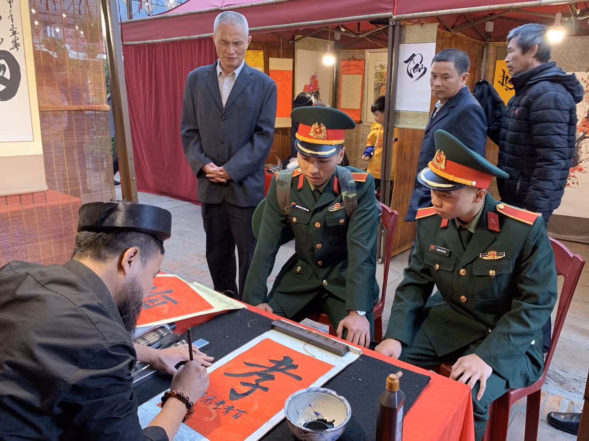 Hai sinh viên Quốc phòng trên đường về nhà ăn Tết cũng ghé qua Hội chữ xuân Canh Tý 2020 để xin chữ. Ảnh: Tùng Dương.