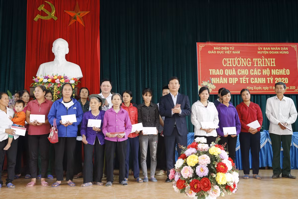 Nhà báo Nguyễn Tiến Bình - Tổng biên tập Báo điện tử Giáo dục Việt Nam và ông Nguyễn Anh Hùng - phó Chủ tịch Ủy ban nhân dân huyện Đoan Hùng, tỉnh Phú Thọ đang trao quà Tết cho hộ nghèo tại xã Hùng Xuyên. Ảnh: Tùng Dương.