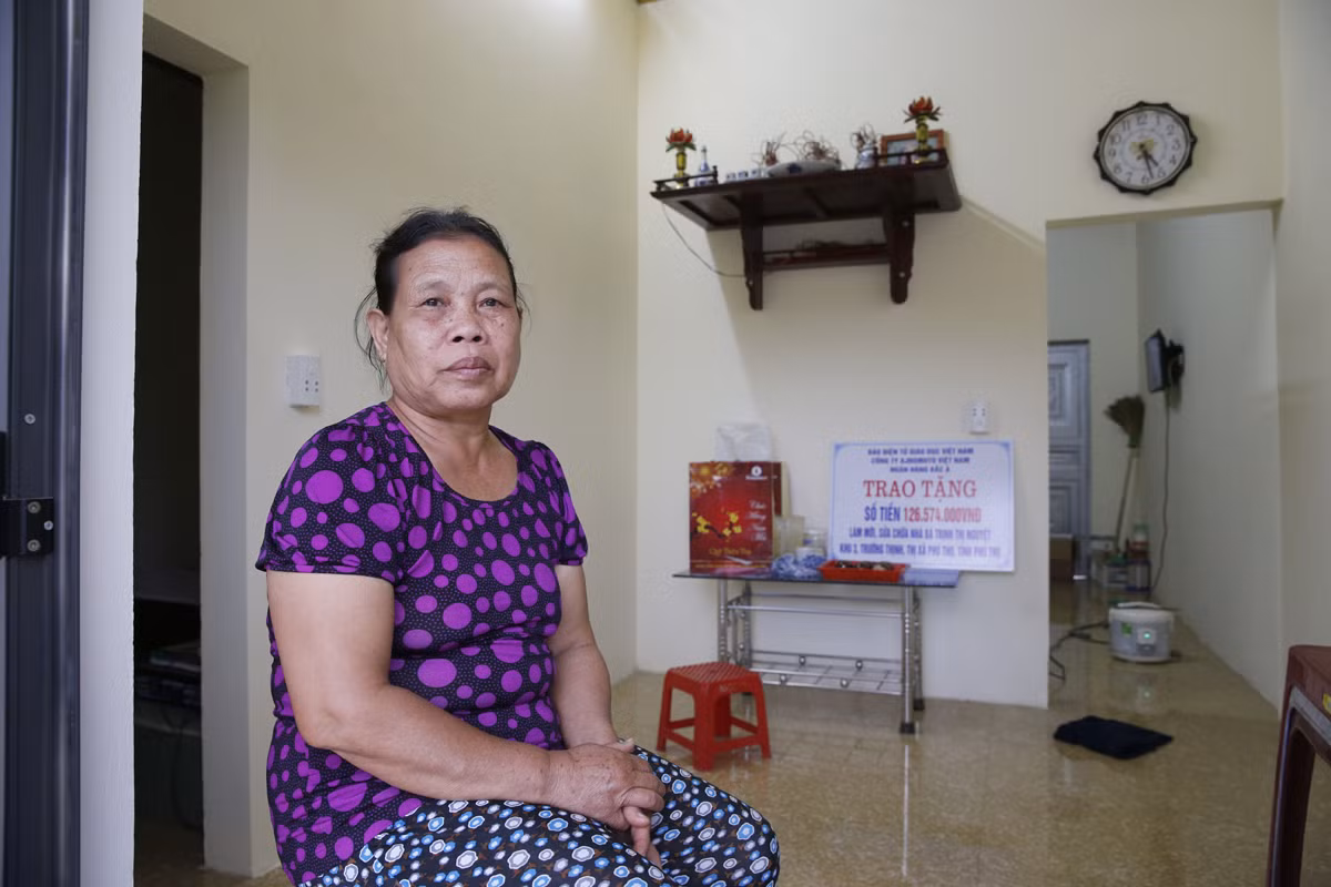 Bà Trịnh Thị Nguyệt ngồi trong căn nhà của mình sau khi được làm mới và sửa chữa. Ảnh: Tùng Dương.