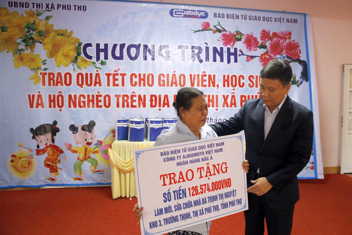 Nhà báo Nguyễn Tiến Bình - Tổng biên tập Báo điện tử Giáo dục Việt Nam trao tặng số tiền để làm mới và sửa chữa căn nhà cho bà Trịnh Thị Nguyệt 67 tuổi. Ảnh: Tùng Dương.