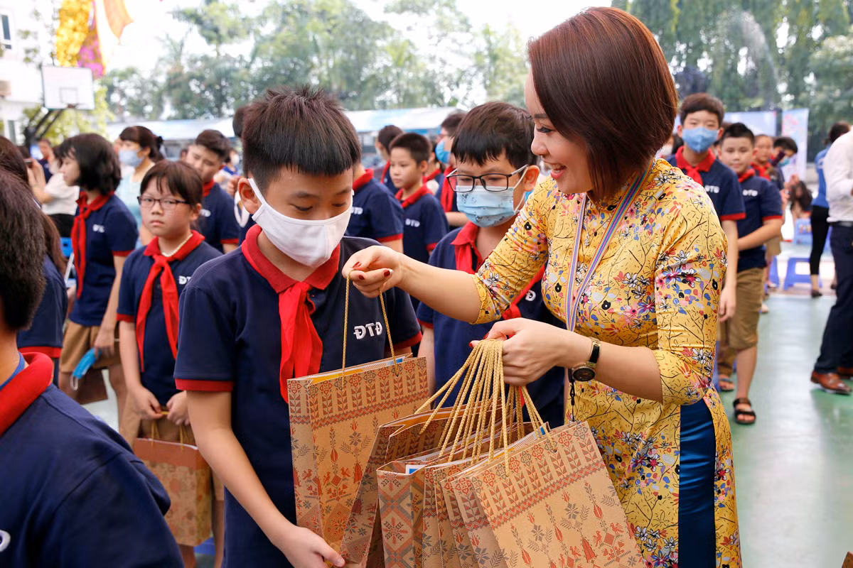 Giáo viên Trường Trung học cơ sở - Trung học phổ thông Đoàn Thị Điểm (Hà Nội) trao quà cho các em học sinh lớp 6 của nhà trường trong lễ khai giảng năm học mới 2020 - 2021. Ảnh: Tùng Dương.