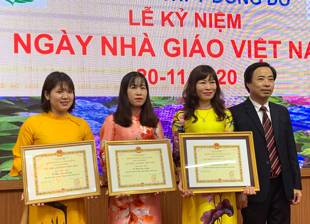 Ông Đàm Xuân Quang (bên phải ảnh) trao Bằng khen danh hiệu Tập thể lao động Tiên tiến của Sở Giáo dục và Đào tạo Hà Nội cho Tổ Khoa học tự nhiên, Khoa học xã hội, Khoa học Giáo dục Trường Trung học phổ thông Đông Đô. Ảnh: Tùng Dương.