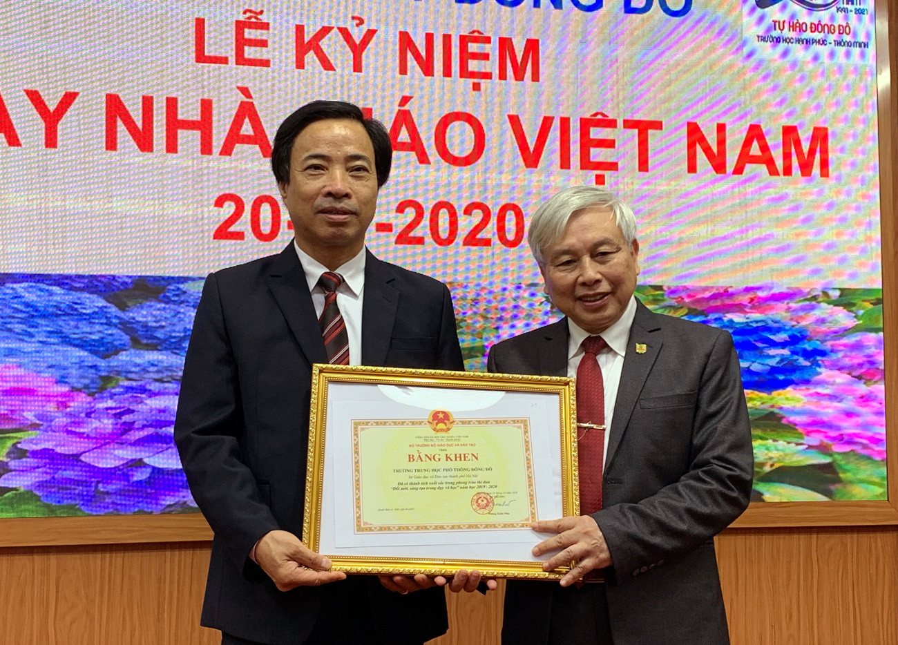 Ông Đàm Xuân Quang (bên trái ảnh) đang trao tặng Bằng khen của Sở Giáo dục và Đào tạo Hà Nội cho Tiến sĩ Võ Thế Quân - Hiệu trưởng Trường Trung học phổ thông Đông Đô. Ảnh: Tùng Dương.