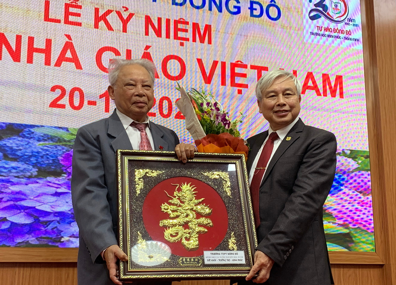 Tiến sĩ Võ Thế Quân (bên phải ảnh) - Hiệu trưởng Trường Trung học phổ thông Đông Đô trao kỷ niệm chương cho Giáo sư Nguyễn Mậu Bành. Ảnh: Tùng Dương.
