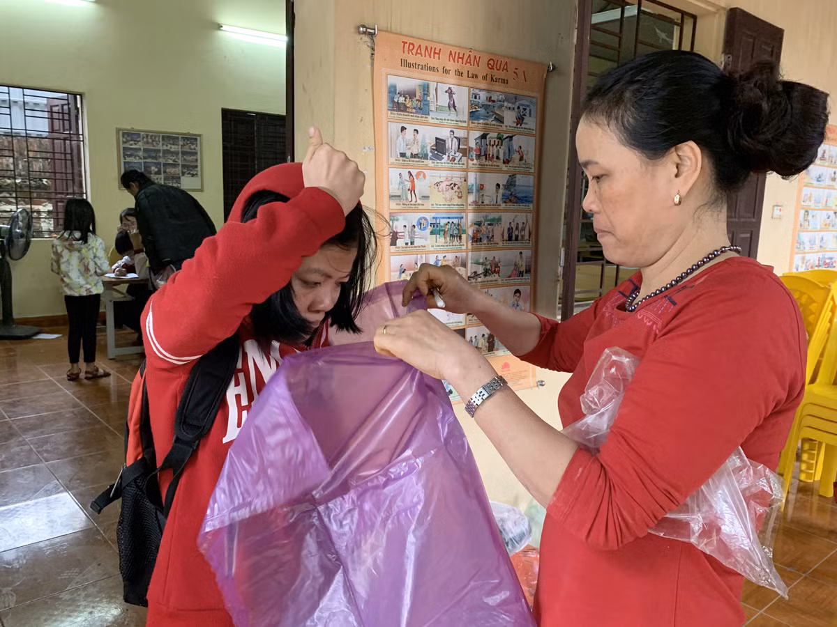 Cô giáo Hòa chuẩn bị áo mưa cho các con sau giờ học. Ảnh: Tùng Dương.