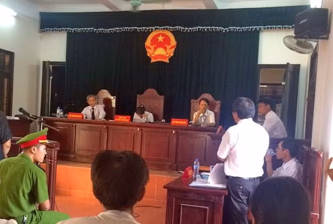 Luật sư Trần Đình triển trình bày, Chủ tọa phiên tòa nghe điện thoại (ảnh: Báo Xây dựng)