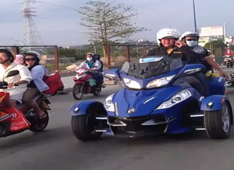 Một người vừa điều khiển chiếc xe Can - Am Spyder vừa nghe điện thoại. Một người vừa điều khiển chiếc xe Can - Am Spyder vừa nghe điện thoại.