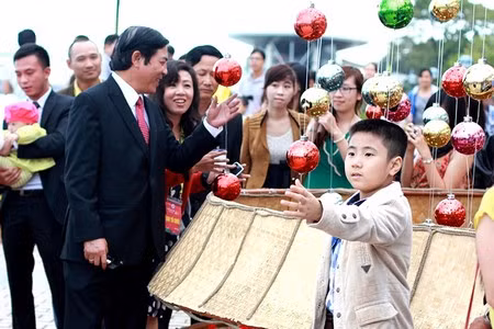 Ông nở nụ cười với một em nhỏ được bố bế trên tay