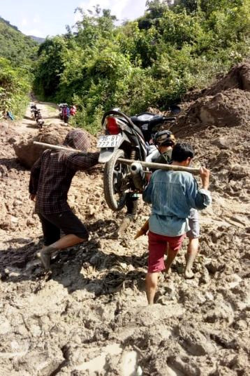 Thầy Long phải cho xe lên đòn gánh để vượt những đoạn đường bùn đất (Ảnh: Lang Văn Long)