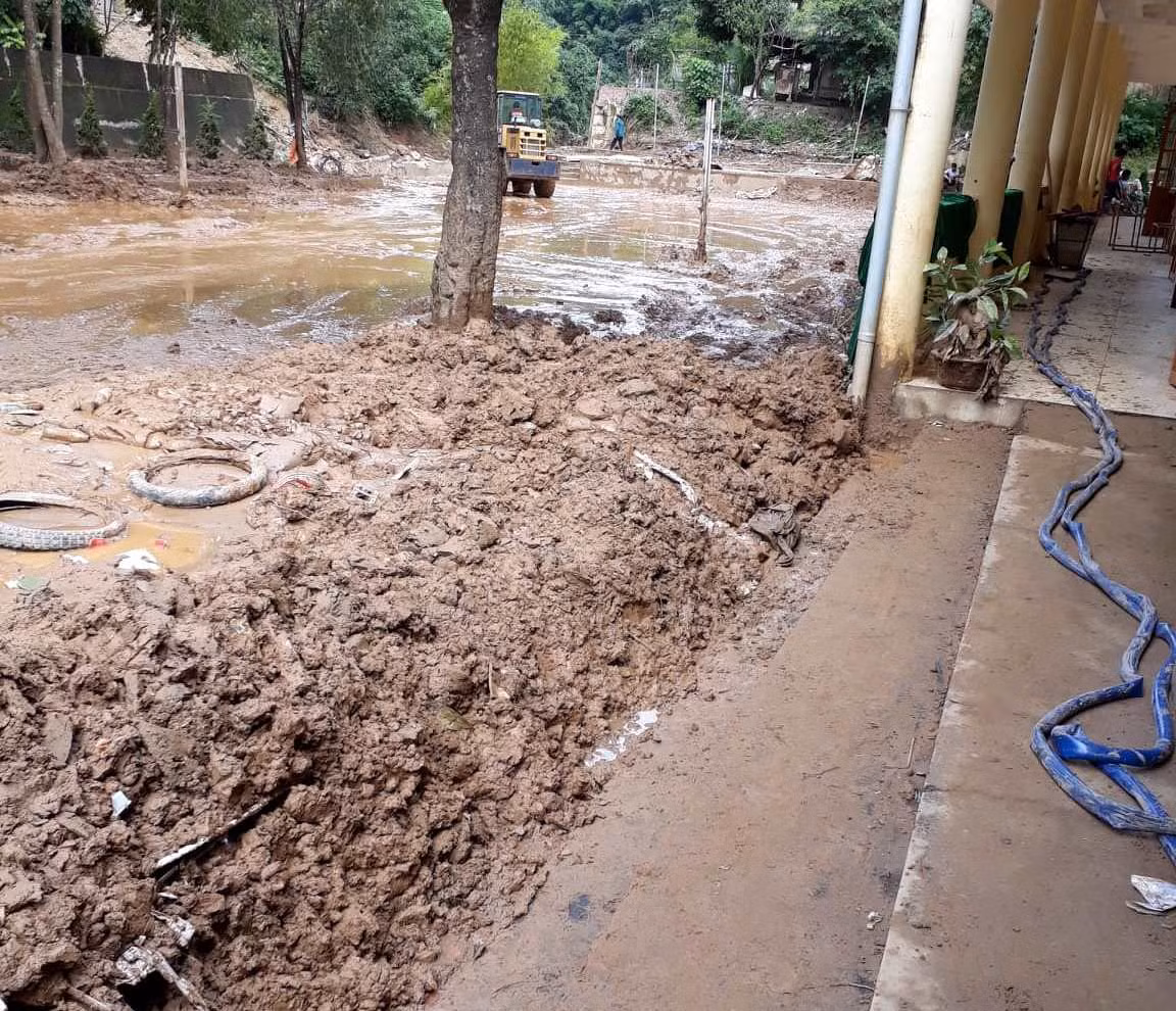 Hình ảnh sân Trường Nà Ớt còn ngập bùn đất, bởi vậy để kịp khai giảng nhà trường bố trí mượn nhà văn hóa để tổ chức. Ảnh: Giáo viên gửi.