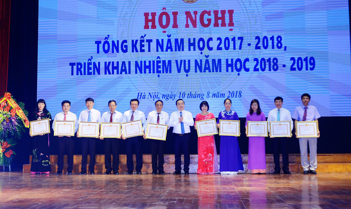 Giám đốc Sở Giáo dục và Đào tạo Hà Nội Chử Xuân Dũng trao bằng khen của Ủy ban nhân dân thành phố cho các đơn vị trong lễ tổng kết năm học ngày 10/8/2018. Ảnh: hanoi.edu.vn.
