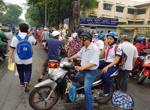 Chở con ra về, chuẩn bị tiếp tục cho bài làm thi vào buổi chiều (Ảnh: P.L) Chở con ra về, chuẩn bị tiếp tục cho bài làm thi vào buổi chiều (Ảnh: P.L)