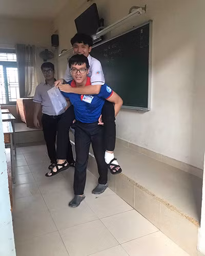 Nam thí sinh được sinh viên Khôi cõng lên tận phòng thi (ảnh: VHU) Nam thí sinh được sinh viên Khôi cõng lên tận phòng thi (ảnh: VHU)