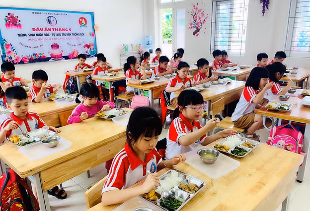 Các em học sinh trường tiểu học Nam Từ Liêm – Hà Nội thưởng thức thực đơn bữa trưa từ Phần mềm.
