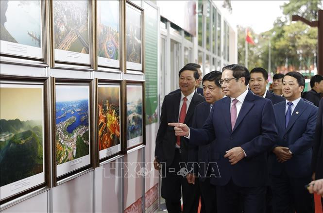Thủ tướng Phạm Minh Chính và các đại biểu xem Triển lãm ảnh "Tây Nguyên xanh- Hài hoà- Bền vững". Ảnh: Dương Giang/TTXVN