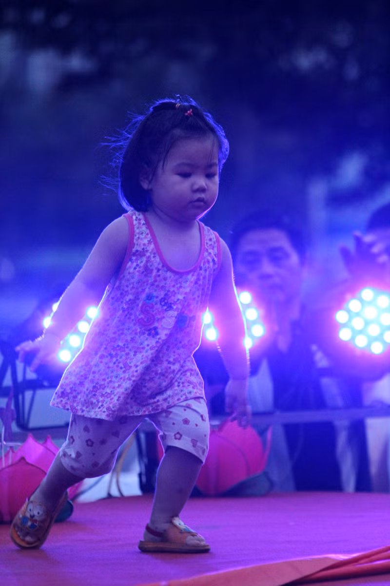 Tại các quận, huyện ở Hà Nội những ngày này thường dựng các sân khấu ngoài trời để tổ chức Tết trung thu các các cháu, trong ảnh là một bé gái nô đùa trước ánh đèn điện tại một sân khấu ngoài trời của Quận Cầu Giấy.