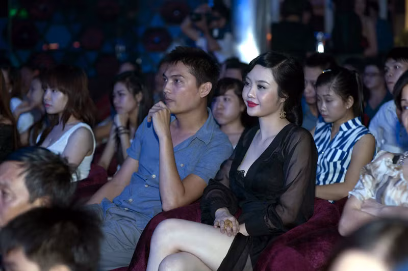 Julia Hồ ngồi một mình khi Đinh Phương Ánh biểu diễn trên sân khấu.