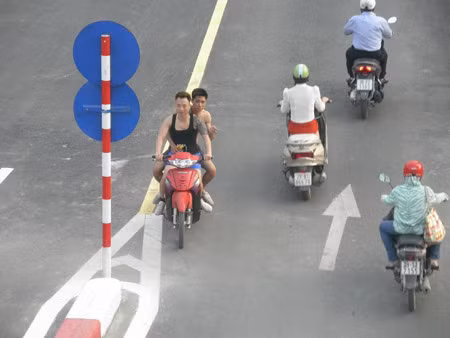 Hai thanh niên xăm trổ đầy mình, không đội mũ bảo hiểm và ngang nhiên đi ngược chiều trên cầu.
