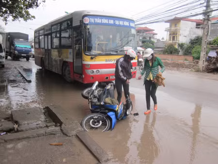 Cảnh người đi đường sập bẫy ổ gà thường xuyên xảy ra trên tuyến đường Ngô Gia Tự, Hà Nội. Ảnh: Văn Định/ Lao động