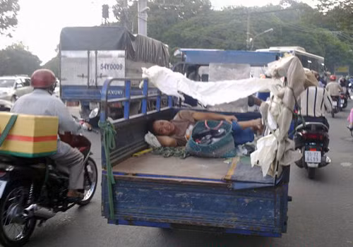 Vui vẻ nằm sau thùng xe 3 bánh.