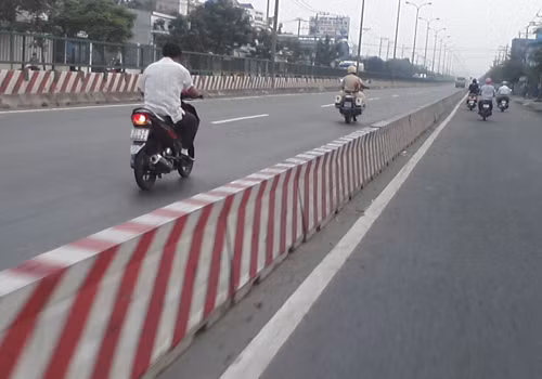 Người dân đi xe máy vào làn của ô tô tại quốc lộ 22, huyện Hóc Môn. Ảnh: Trần Thanh Quốc.