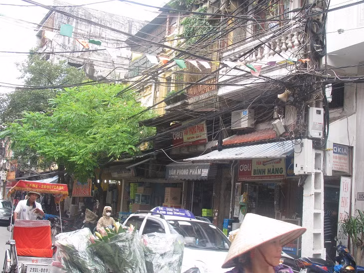 Dây điện, dây cáp tủa ra từ các cột điện và kéo dài trên phố Hàng Cân. Dây điện, dây cáp tủa ra từ các cột điện và kéo dài trên phố Hàng Cân.