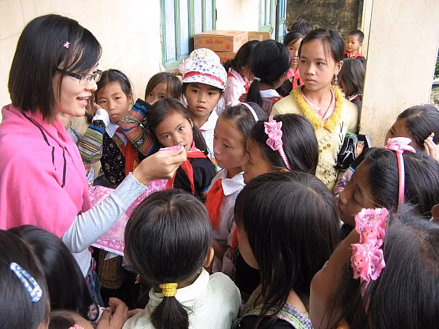 Phóng viên Báo GDVN đang tặng vào đeo cho các em nhỏ từng chiếc cặp tóc. Gần như chưa bao giờ các em có được một món quà như thế. Những dịp tặng quà của các nhà hảo tâm thế này là dịp động viên các em trong học tập. Ảnh Xuân Trung