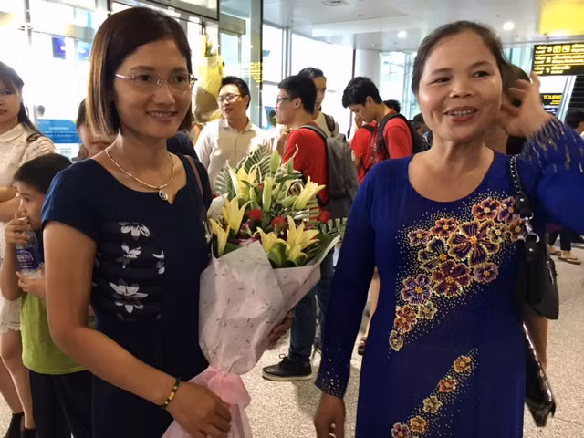 Mẹ của Lê Quang Tuấn - học sinh giành Huy chương Vàng Olympic Tin học 2017 (phải) và đại diện xã Minh Khai (Hoài Đức, Hà Nội) chờ đợi để chúc mừng thành tích của Tuấn. Được biết, lãnh đạo xã đã thưởng cho Tuấn 1 triệu đồng để khích lệ em.